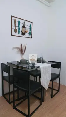 a black dining room table with black chairs and a picture at Aludia's Dreamplace in Manila
