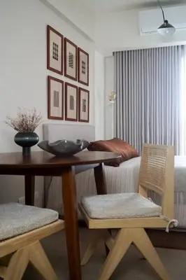 a room with a table and chairs and a bedroom at The Florentine Suite in Manila