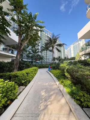 a sidewalk in front of a building with palm trees at Ohana JPL Azure Staycation in Manila