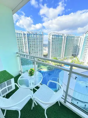 a balcony with a table and chairs and buildings at Ohana JPL Azure Staycation in Manila