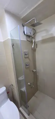 a bathroom with a shower and a toilet at The Shore 3 Chic Suite in Manila