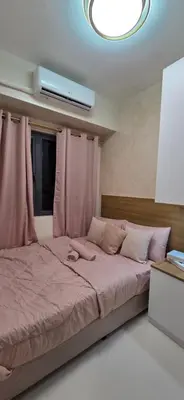 a bedroom with a large bed with pink curtains at The Shore 3 Chic Suite in Manila