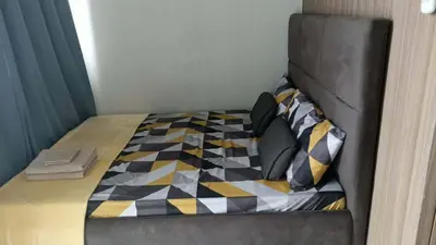 a bed with a checkered blanket and pillows on it at SM Mall of Asia Shore2 Tower2 Nano Nap&Go in Manila