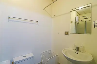 a bathroom with a sink and a toilet and a mirror at Comfy 1BR Self Check-In at Light Residences in Manila
