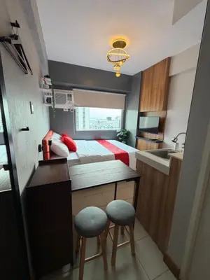 a small room with a bed and a kitchen at PaulBert's Cabins III in Manila
