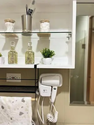 a bathroom with a hair dryer under a shelf at Spacious 2BR in Shore3 in Manila