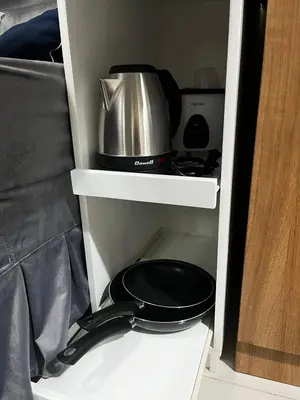 a white cabinet with a pot and a pan in it at Spacious 2BR in Shore3 in Manila