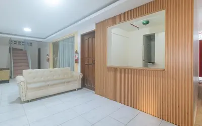 a living room with a couch and a mirror at RedDoorz at FCCG GoldMoon Boutique Hotel in Manila
