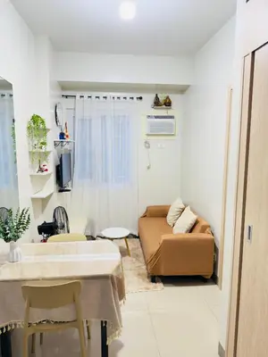 a living room with a couch and a table at Cozy Condo at SMDC Charm Cainta in Manila