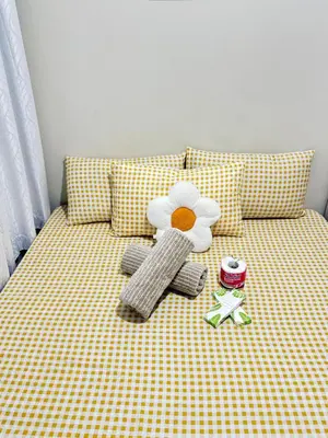 a yellow and white bed with a toy flower on it at Cozy Condo at SMDC Charm Cainta in Manila