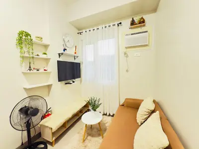 a living room with a couch and a tv at Cozy Condo at SMDC Charm Cainta in Manila
