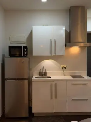 a kitchen with white cabinets and a refrigerator at Deluxe Room with Pool View Unit in Poblacion in Manila
