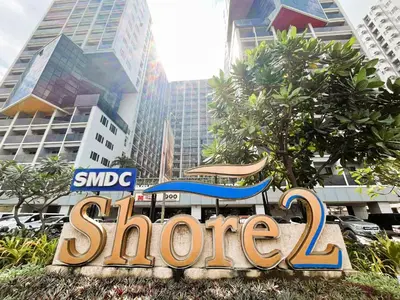a sign for a store in front of buildings at Ameera Condo Stay in Manila