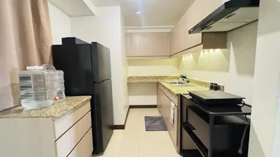a kitchen with a black refrigerator and a sink at Brand New Cozy 2 BR unit in Pasig in Manila