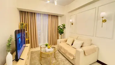 a living room with a couch and a tv at Brand New Cozy 2 BR unit in Pasig in Manila