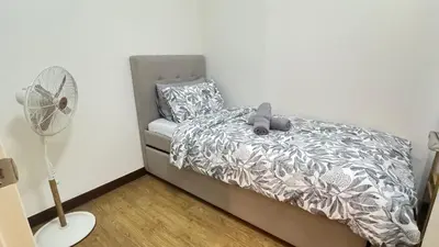 a small bedroom with a bed with a fan at Brand New Cozy 2 BR unit in Pasig in Manila