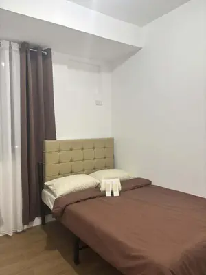 a bedroom with a bed with a headboard and curtains at Condo Unit in Parañaque by Casa Esplanade in Manila