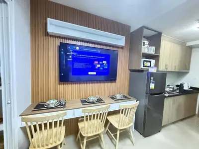 a kitchen with a table and a television on a wall at NEW One Bedroom Condo Unit in Manila
