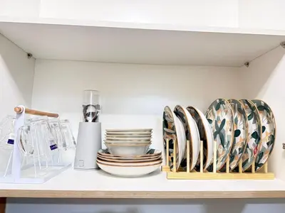 a shelf with plates and other kitchen utensils on it at NEW One Bedroom Condo Unit in Manila