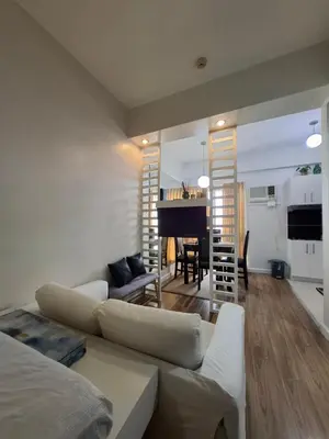 a living room with a couch and a piano at Cozy Hotel-Style Studio Unit for Rent at Eastbay Residences by Rockwell in Manila