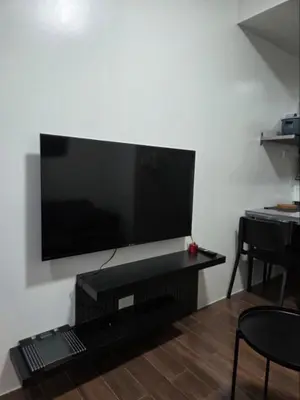 a living room with a large flat screen tv on a wall at Air Residences in Manila