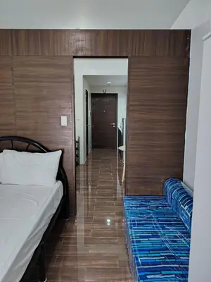 a bedroom with a bed and a hallway at Air Residences in Manila