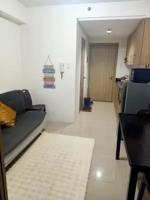 a living room with a couch and a kitchen at Staycation in Shore Residence's in Manila