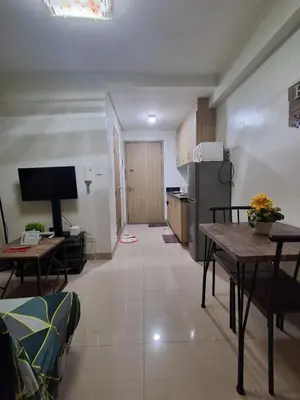 a living room with a table and a kitchen at 3sonstaycation in Manila