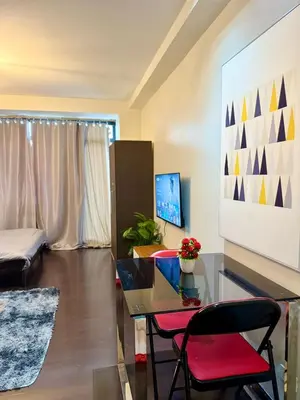 a living room with a glass table and red chairs at Makati City Poblacion 1 bedroom with balcony in Manila
