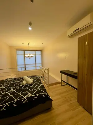a bedroom with a bed and a desk and a window at Makati City Poblacion 1 bedroom with balcony in Manila