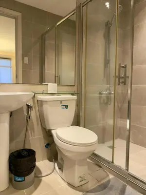 a bathroom with a toilet and a shower and a sink at Makati City Poblacion 1 bedroom with balcony in Manila