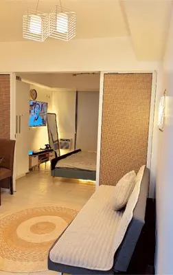 a room with two beds and a living room at 1BR 4Pax Condo Azure Beach Resort Pool View Fully Furnished with PS4 in Manila