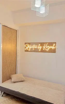 a bed in a room with a sign on the wall at 1BR 4Pax Condo Azure Beach Resort Pool View Fully Furnished with PS4 in Manila