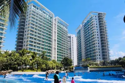 a resort with people in the water in front of tall buildings at Azure Urban Resort Residence Wavepool A52 in Manila