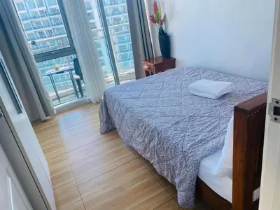 a bedroom with a bed and a large window at Azure Urban Resort Residence Wavepool A52 in Manila