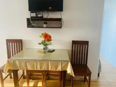 a dining room table with a vase of flowers on it at Azure Urban Resort Residence Wavepool A52 in Manila