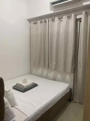 a bed in a room with a window with a cup on it at Shore residence A42 shortwalk mall of asia in Manila