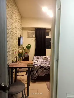 a bedroom with a table and a bed in a room at Urban Deca Tower at Mandaluyong in Manila