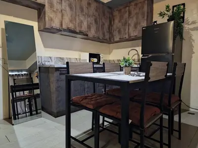 a kitchen with a table with chairs and a refrigerator at Luxe Spacious Cozy Venice BGC 65inTV Surround Sound in Manila