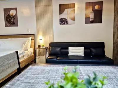 a living room with a couch and a bed at Luxe Spacious Cozy Venice BGC 65inTV Surround Sound in Manila