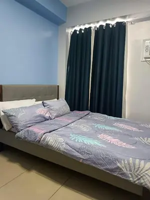 a bed in a room with black curtains at Avida Sucat Paranaque City in Manila