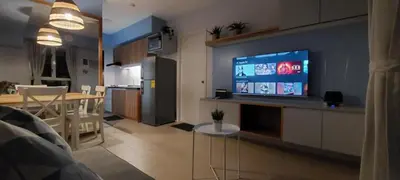 a kitchen and a living room with a tv and a table at Avida Sucat Paranaque City in Manila