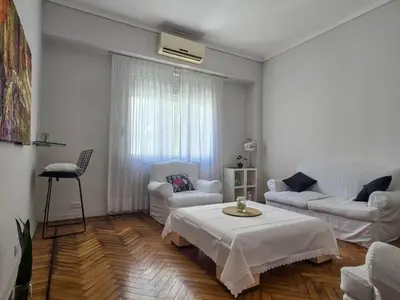 a living room with white furniture and a table at Pure Stay Apartments in Manila