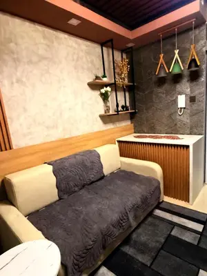 a couch sitting in a room with a bar at Bayshore Getaway Condotel ByClowie in Manila