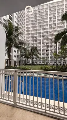 a white fence in front of a large building at Direct Access to pool GK Suite in Manila
