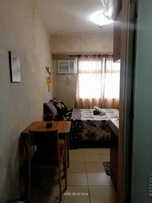 a small room with a bed and a table with a chair at Urban Deca Tower at Mandaluyong in Manila