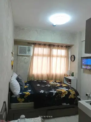 a bedroom with a bed and a window with flowers at Urban Deca Tower at Mandaluyong in Manila