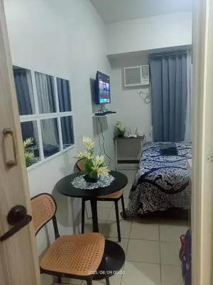 a small room with a table and a bed at Urban Deca Tower at Mandaluyong in Manila