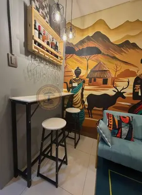 a room with a table and chairs and a mural at Cozy African Home in Parañaque in Manila