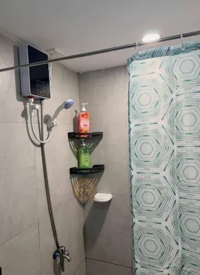 a shower with a glass door in a bathroom at Cozy African Home in Parañaque in Manila